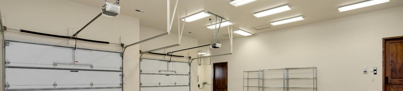 Clean garage interior featuring automatic sectional garage doors and new opener systems installation